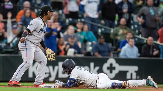 Seattle Mariners' Jose Caballero slides into third base next to Miami Marlins third baseman Jean Segura with a three-run triple during the sixth inning of a baseball game Tuesday, June 13, 2023, in Seattle. (AP Photo/Stephen Brashear)