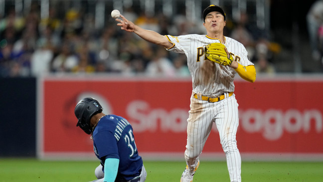 San Diego Padres shortstop Ha-Seong Kim, right, throws to first for the double play as Seattle Mariners' Teoscar Hernandez slides in late to second during the eighth inning of a baseball game Tuesday, June 6, 2023, in San Diego. Seattle Mariners' Cal Raleigh was out at first on the play. (AP Photo/Gregory Bull)