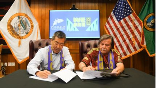   Peter Tomozawa (left) and Puyallup Tribe Chairman Bill Sterud sign to make it official that the tribe will be the cultural sponsor of the Seattle 2026 World Cup organizing committee on June 20, 2023. (Photo: FIFA World Cup)