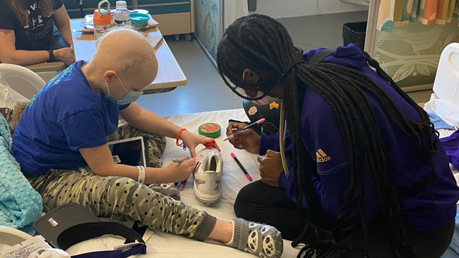 The University of Washington softball team visited patients at Seattle Children's on March 22 and designed cleats together. (Photo courtesy of Seattle Children's)