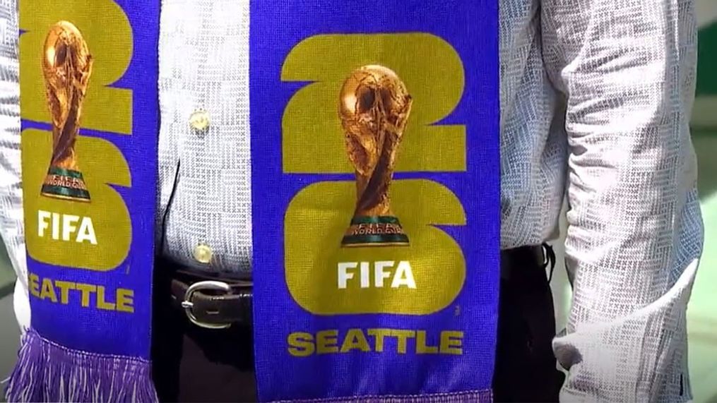Peter Tomozawa, the CEO of the 2026 FIFA World Cup Seattle organizing committee, wears a scarf with the new logo atop the Space Needle on May 18, 2023. (KOMO News)
