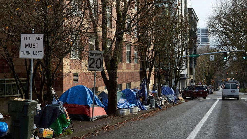 FILE - Tents line the sidewalk on SW Clay St in Portland, Ore., on Dec. 9, 2020. People with disabilities in Portland have filed a class action lawsuit in federal court, Thursday, Sept. 8, 2022, claiming the city has failed to keep sidewalks accessible by allowing homeless tents and encampments to block sidewalks. (AP Photo/Craig Mitchelldyer, File)
