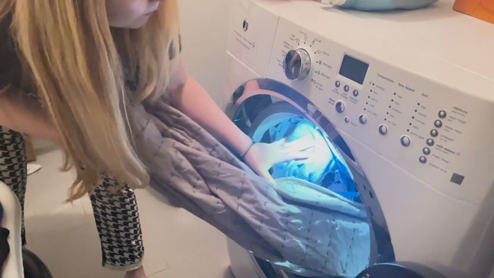 FILE – A woman loads a washing machine. Consumer Reports said undergarments like t-shirts, socks, and especially gym clothes, should be washed after each use. (Photo: KOMO News via Consumer Reports)