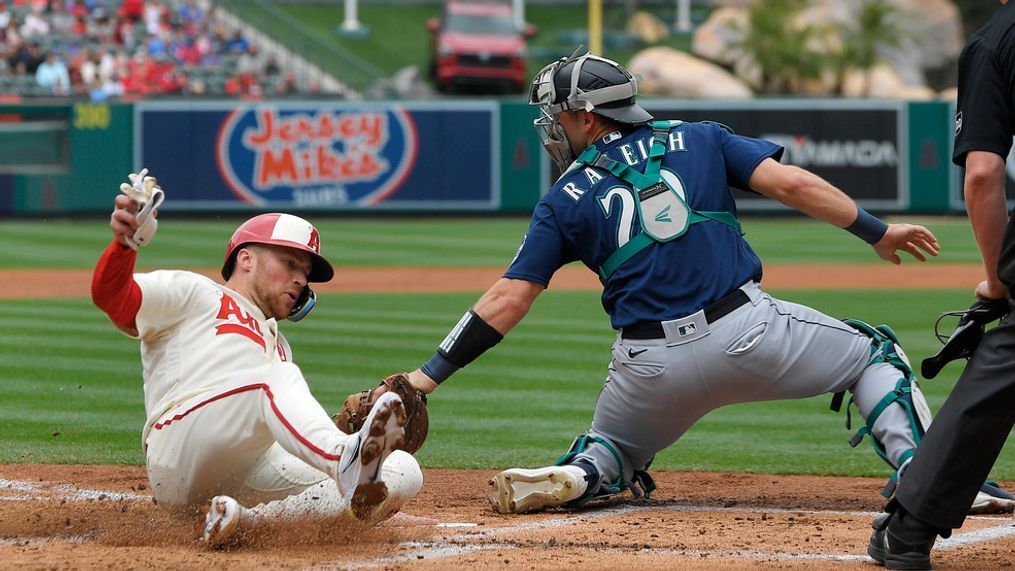 Los Angeles Angels' Brandon Drury, left, scores on a single by Matt Thaiss as Seattle Mariners catcher Cal Raleigh makes a late tag during the first inning of a baseball game Sunday, June 11, 2023, in Anaheim, Calif. (AP Photo/Mark J. Terrill)