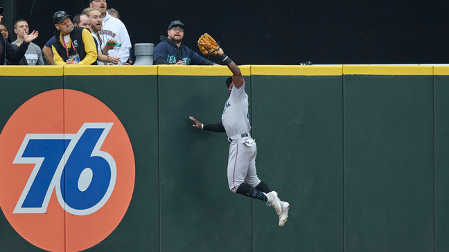 Miami Marlins center fielder Jonathan Davis leaps at the wall, catching a ball hit by Seattle Mariners' Teoscar Hernandez during the first inning of a baseball game Wednesday, June 14, 2023, in Seattle. (AP Photo/John Froschauer)