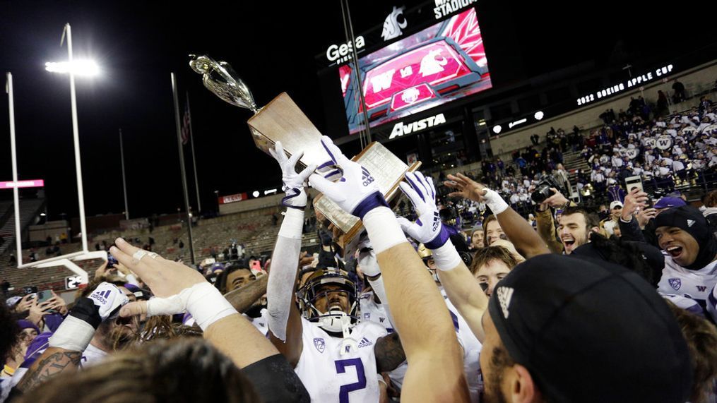 Washington players celebrate with the Apple Cup Trophy after their 51-33 win against Washington State in an NCAA college football game, Saturday, Nov. 26, 2022, in Pullman, Wash. (AP Photo/Young Kwak)