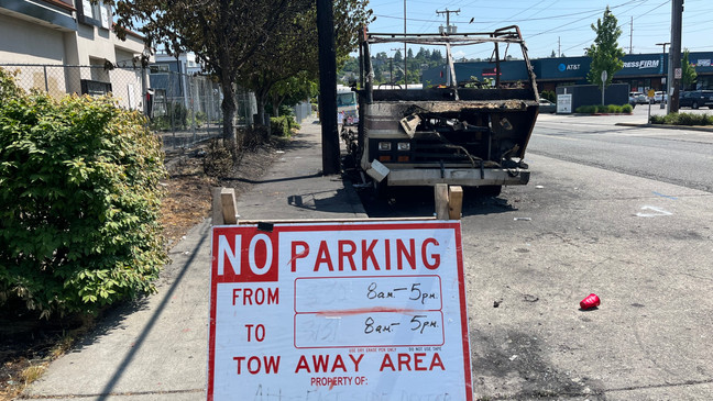 A no parking sign near an RV that was destroyed in a fire along Northwest Ballard Way. Notices were placed on RVs parked at the encampment saying residents had 72 hours to move or risk being towed. (KOMO News)